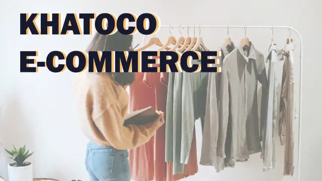 Khatoco E-commerce — a shopper holding a phone while browsing shirts on a clothing rail