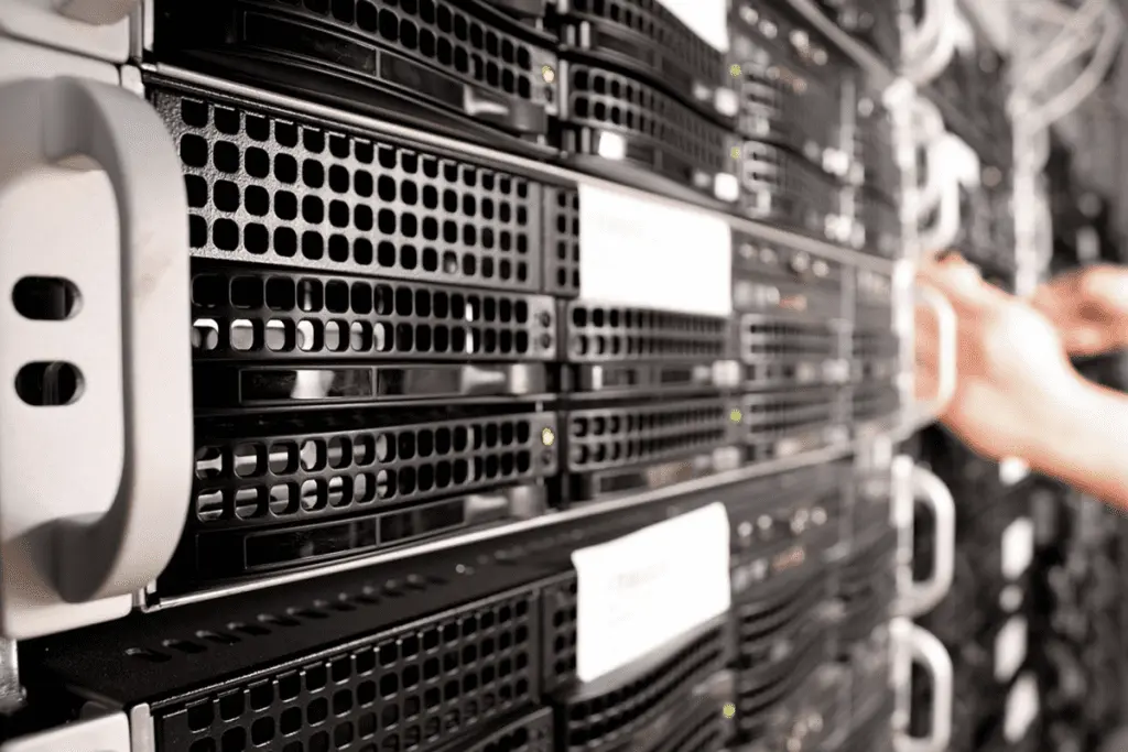 Rows of rack-mounted servers with a hand reaching toward one