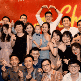 The team making heart shapes with their hands at an evening event